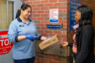 Employee with business customer hands off USPS Connect™ Local package at receiving dock of designated Postal facility.